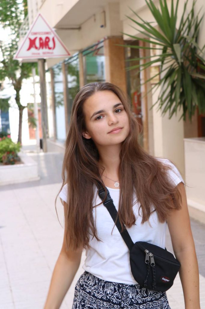 Sabeth wearing a white t-shirt and a black skirt.