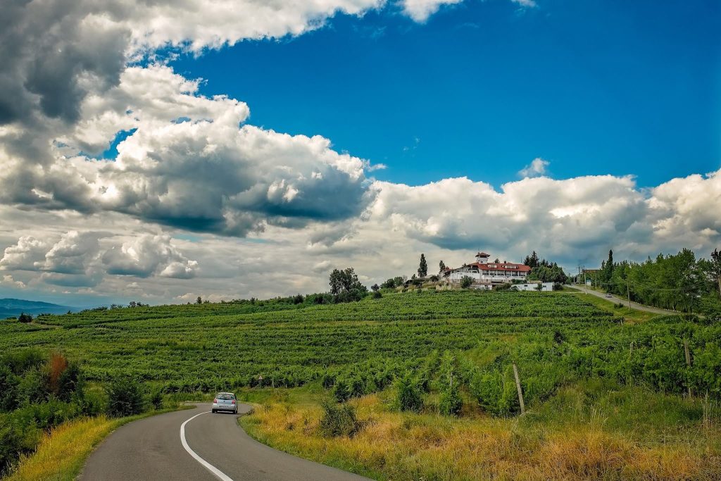 A car driving on a country road during a cloudy day in Romania.